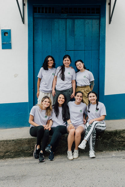 Group of women from unblended coffee posing in front of a blue door